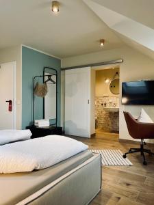 a bedroom with a bed and a desk and a chair at Hotel-Bistro-Europa in Merchweiler