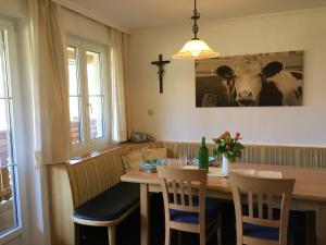Knirschenhof في فينديشغارشتن: طاولة غرفة طعام مع كراسي وصورة بقرة على الحائط