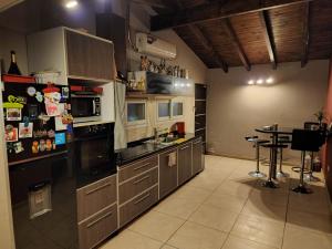 een keuken met roestvrijstalen apparatuur en een tafel bij Casa quinta en Pocito con pileta quincho cancha de futbol in Pocito