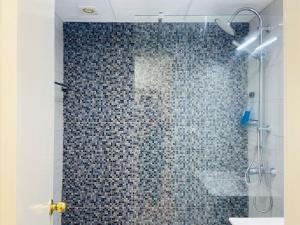 ein Bad mit einer Dusche und einer blau gefliesten Wand in der Unterkunft Estudio castle harbour 403 los Cristianos in Los Cristianos + 10 Fotos
