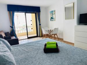 ein Schlafzimmer mit einem Bett mit einem grünen Kissen darauf in der Unterkunft Estudio castle harbour 403 los Cristianos in Los Cristianos