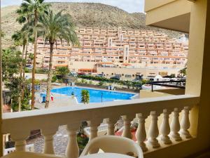 einen Balkon mit Blick auf ein Hotel und einen Pool in der Unterkunft Estudio castle harbour 403 los Cristianos in Los Cristianos