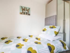 - une chambre avec un lit et une couette jaune et blanche dans l'établissement Hunrosa, à Redruth