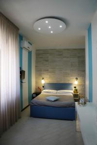 a bedroom with a bed and a blue wall at Guest House Le Tre Isole Sorrento in Sorrento