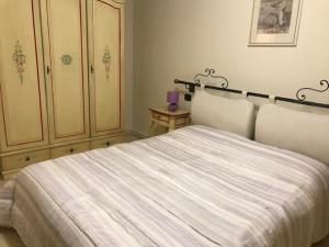 sypialnia z białym łóżkiem i szafką w obiekcie Appartamento Du Lac 2 w mieście Desenzano del Garda