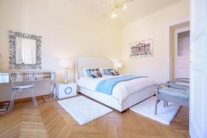 a bedroom with a bed and a table and a mirror at James Joyce Luxury Apartment in Trieste
