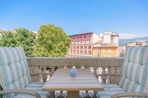 a table and two chairs on a balcony at James Joyce Luxury Apartment in Trieste