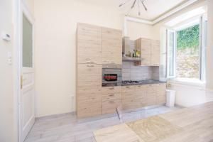 a kitchen with white walls and wooden cabinets at James Joyce Luxury Apartment in Trieste
