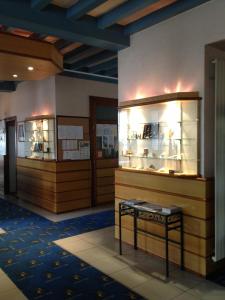 a room with two display cabinets and a stool at Hôtel de Nevers in Lourdes