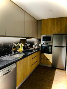 eine Küche mit Küchengeräten aus Edelstahl und Holzschränken in der Unterkunft Quinta do Cascalheiro in Leiria