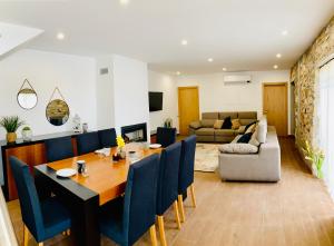 a dining room and living room with a table and chairs at Quinta do Cascalheiro in Leiria
