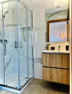 uma casa de banho com uma cabina de duche em vidro e um lavatório. em Quinta do Cascalheiro em Leiria