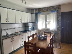 a kitchen with a wooden table and a dining room at Casa Mirian in Arroyo Frio