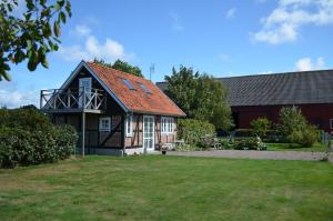 une maison avec un toit rouge et une cour dans l'établissement Hönshuset Kullabygden, à Höganäs