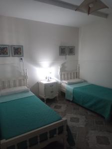 1 dormitorio con 2 camas y mesa con lámpara en Casa Termas en Termas de Río Hondo