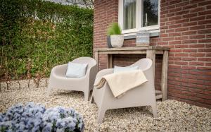 twee stoelen en een tafel op een patio bij 't Tuinhoes in Reuver