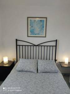 1 dormitorio con 1 cama con 2 lámparas y una foto en la pared en Apartamento Puerto de la Estaca 1 en Valverde