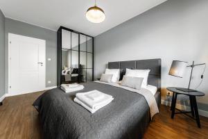 una camera da letto con un grande letto con asciugamani bianchi di Aparthotel Plac Litewski Premium a Lublino