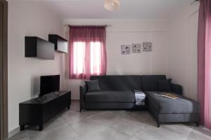 a living room with a couch and a tv at mansion luxury apartment in Psakoudia