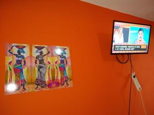 TV de pantalla plana colgada en una pared con 2 posters en Norte Alojamiento en Belén
