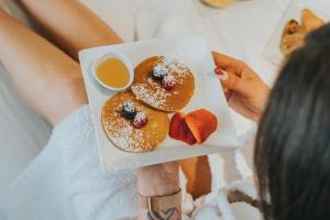 a woman holding a plate of donuts and strawberries at Sweet Atlantic Hotel & Spa in Figueira da Foz