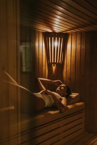 a woman is laying in a sauna at Sweet Atlantic Hotel & Spa in Figueira da Foz