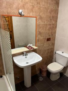 a bathroom with a sink and a toilet and a mirror at Hostal Ciudad Encantada in Cuenca +19 photos