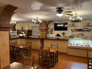 a restaurant with tables and chairs and a bar at Hostal Ciudad Encantada in Cuenca