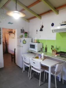 een keuken met een tafel en een witte koelkast bij Myrovolos in Armenistis