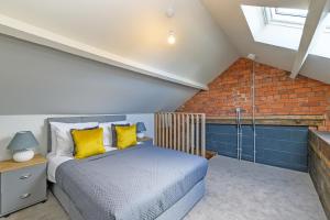 a bedroom with a bed and a brick wall at Carriage Works Apartments in Preston in Preston