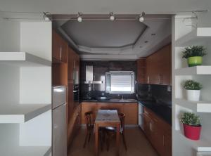 a kitchen with wooden cabinets and a table in it at The Countryside in Sarandë