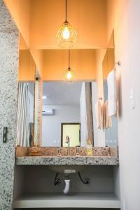 a bathroom with a sink and a large mirror at A Fazenda eventos e lazer Lindomar Gonçalves in Piumhi