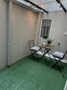 un patio con 2 sillas y una mesa con una planta en Apartamento centrico Venecia, en Sevilla