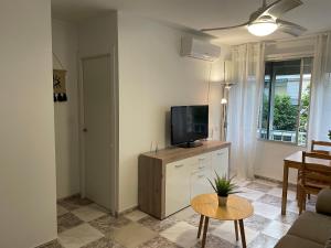 een woonkamer met een televisie en een tafel bij Apartamento centrico Venecia in Sevilla