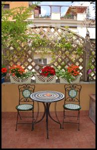 a patio table and two chairs with a table and flowers at Lilium Boutique Hotel in Rome