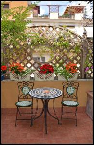 a table topped with flowers and a table with chairs at Liliumhotel in Rome