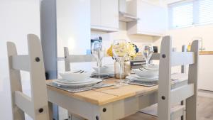 una mesa de comedor con platos y vasos. en Contractors&Leisure - Bedford Hospital & City Centre inc Private Parking en Bedford