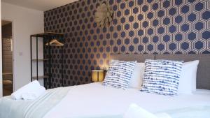 1 dormitorio con 1 cama grande con almohadas azules y blancas en Contractors&Leisure - Bedford Hospital & City Centre inc Private Parking en Bedford