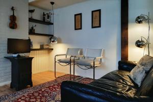 Sint-Oedenrode的住宿－Gastenverblijf 't Nagtegaeltje，客厅配有沙发、两把椅子和电视