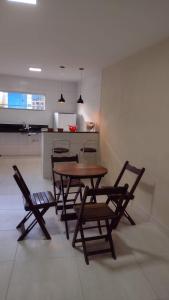 Praia de Setiba - Kitnet في غواراباري: طاولة وكراسي في غرفة مع مطبخ