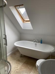 a bathroom with a bath tub and a window at The Hayloft B and B in Newbury