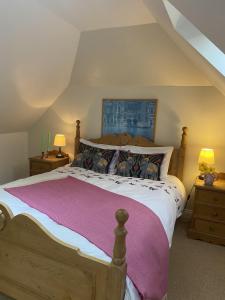 um quarto com uma cama e duas mesas de cabeceira com candeeiros em The Hayloft B and B em Newbury