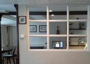 een kamer met een raam en een tv. bij Gastenverblijf 't Nagtegaeltje in Sint-Oedenrode