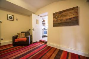 uma sala de estar com uma cadeira e um quadro na parede em Manorbier Castle Inn Sunset Room em Tenby