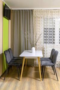 una mesa y dos sillas con un jarrón. en Wandorf 125 Apartman, en Sopron