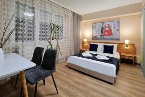 a bedroom with a bed and a table and chairs at Wandorf 125 Apartman in Sopron