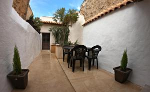 a patio with black chairs and a table and potted plants at Casa Rural Guadiela II in San Pedro Palmiches