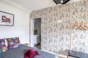 - une chambre avec un mur orné d'un papier peint à fleurs dans l'établissement Charmante maison de ville, à Périgueux