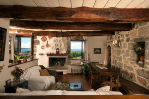 sala de estar con chimenea y pared de piedra en The view with a room, en Bolsena