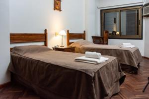 Dos camas en una habitación de hotel con toallas. en Catalina Hotel San Pedro de Jujuy en San Pedro de Jujuy